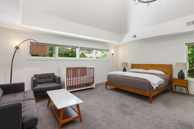 carpeted bedroom with baseboards, a high ceiling, and visible vents