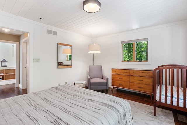 bedroom featuring crown molding, dark wood-style flooring, and visible vents