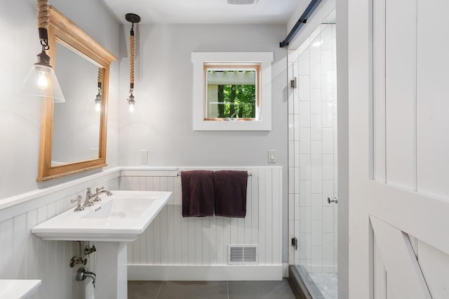 full bathroom with a stall shower, visible vents, tile patterned flooring, and a wainscoted wall