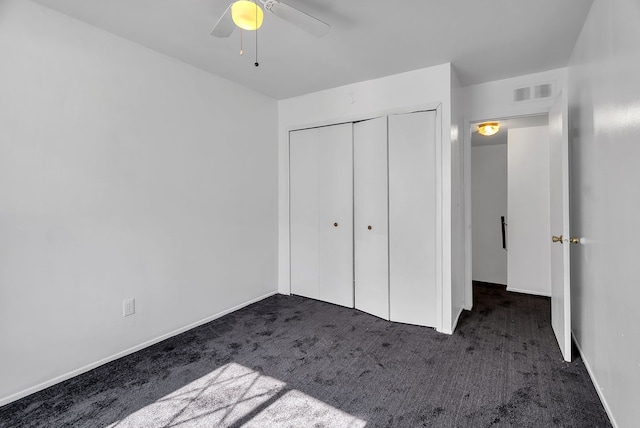 unfurnished bedroom with ceiling fan, visible vents, carpet floors, baseboards, and a closet