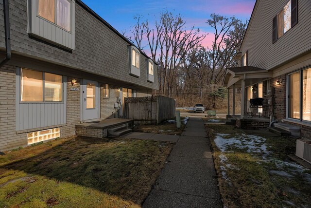 view of home's exterior featuring brick siding and a shingled roof
