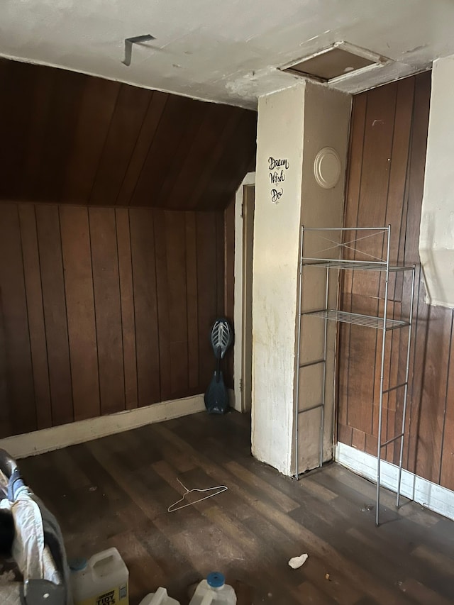 bonus room featuring wood walls, lofted ceiling, and dark wood-style floors