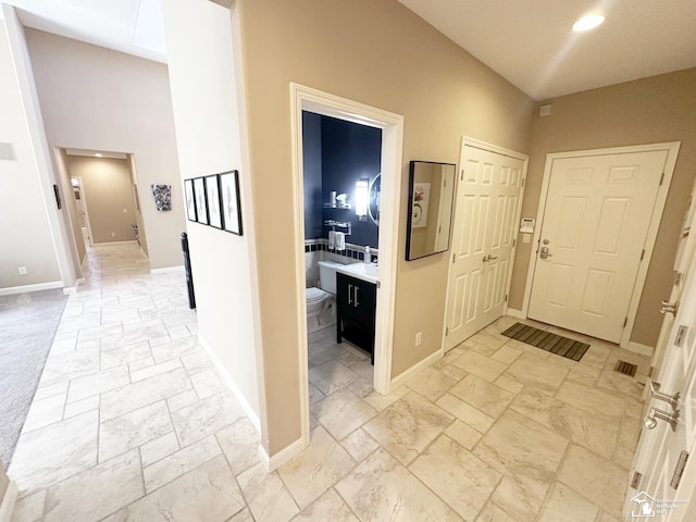 foyer with baseboards, recessed lighting, and stone tile flooring