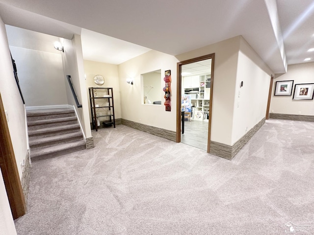 basement with carpet flooring, baseboards, and stairs