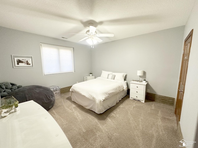 carpeted bedroom featuring a ceiling fan, a textured ceiling, and visible vents