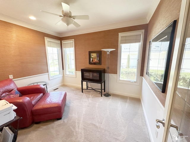 living area featuring plenty of natural light, carpet floors, and a wainscoted wall