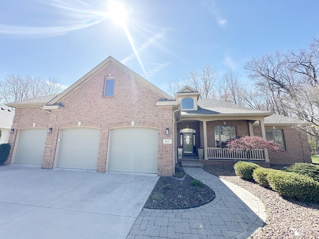 view of front of property with covered porch, driveway, roof with shingles, a garage, and brick siding