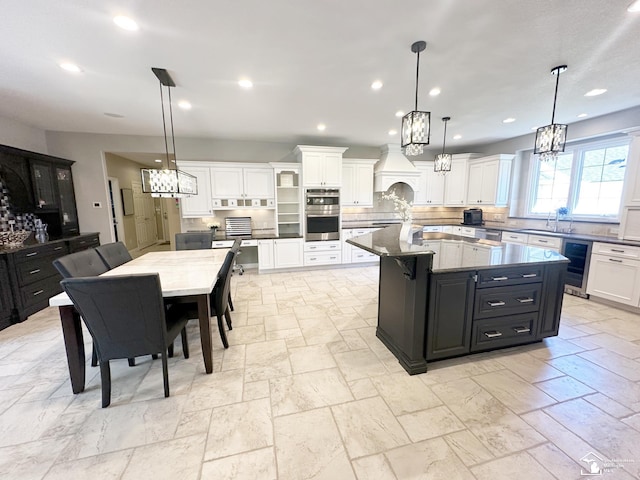 kitchen with beverage cooler, a sink, stainless steel double oven, and white cabinets