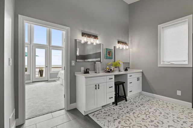 ensuite bathroom with baseboards, ensuite bathroom, vanity, and visible vents