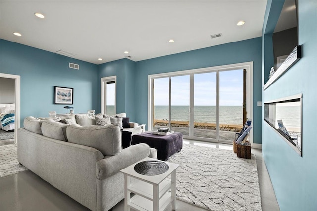 living room featuring visible vents, recessed lighting, baseboards, and a water view