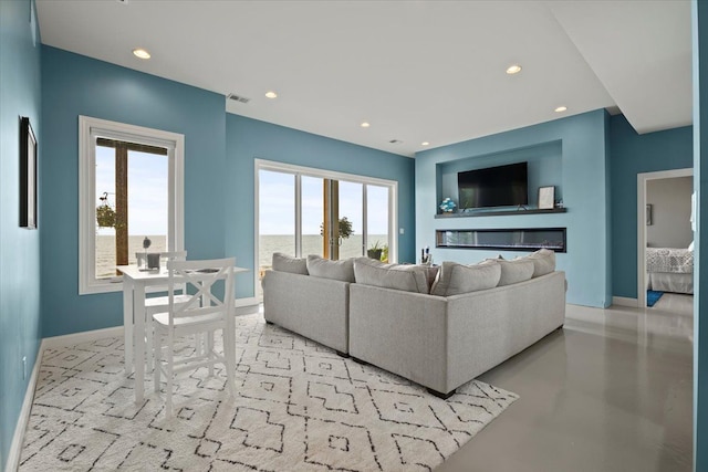 living area with baseboards, recessed lighting, concrete floors, and visible vents