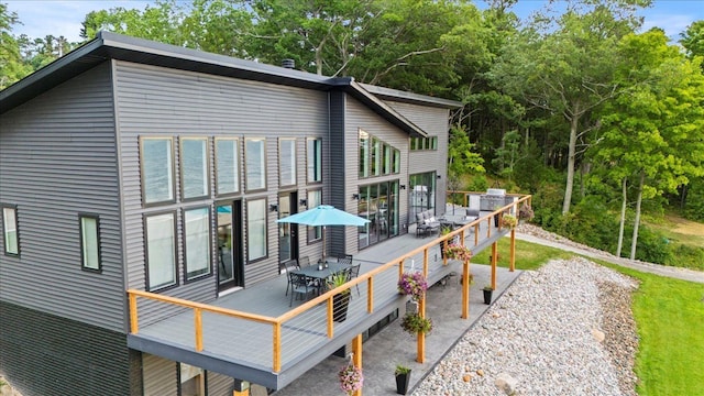 back of house featuring a wooden deck and outdoor dining space