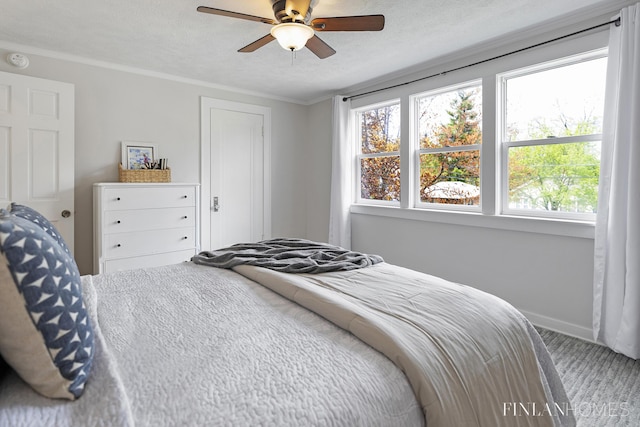 bedroom with baseboards, carpet flooring, ceiling fan, and crown molding
