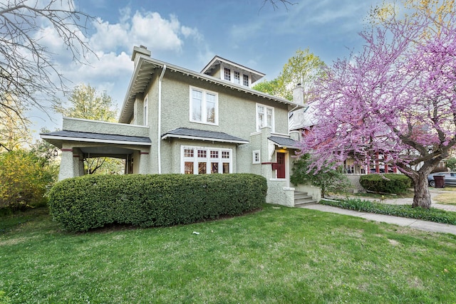 traditional style home with a chimney, stucco siding, and a front yard