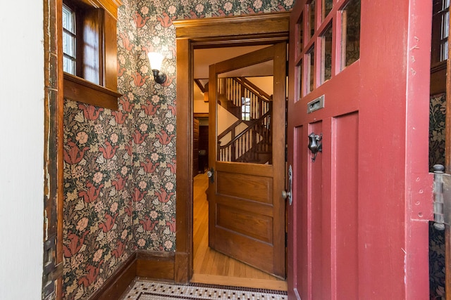 interior space featuring wallpapered walls and baseboards