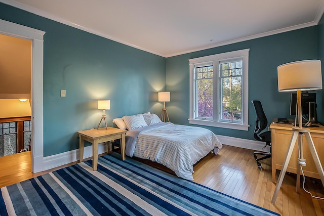 bedroom featuring crown molding, baseboards, and wood-type flooring