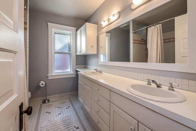 full bathroom with tile patterned flooring, a sink, double vanity, and toilet