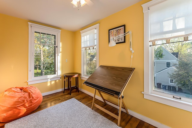 sitting room with baseboards and wood finished floors
