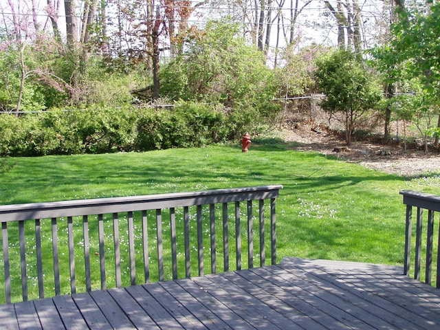 wooden terrace featuring a lawn