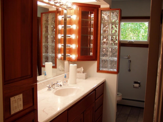 bathroom with vanity, a baseboard radiator, and toilet