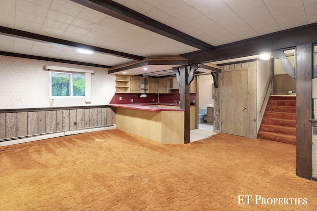 below grade area with wooden walls, stairs, carpet, and a baseboard radiator