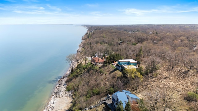 birds eye view of property with a water view and a wooded view