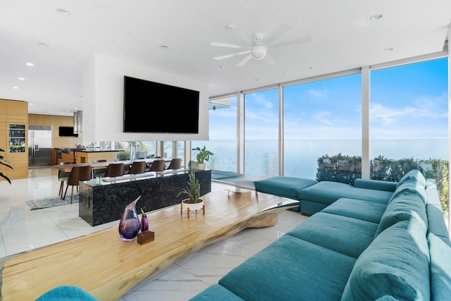 living area featuring floor to ceiling windows, a ceiling fan, recessed lighting, and marble finish floor