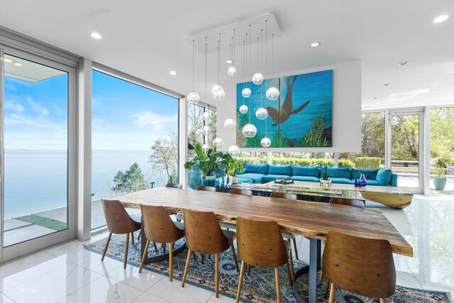 dining space with a water view, recessed lighting, and expansive windows