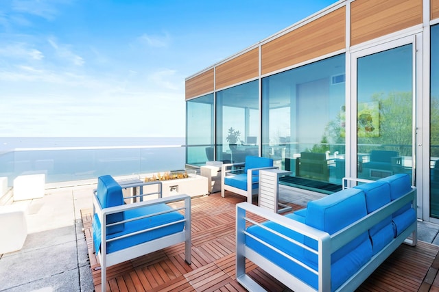 wooden terrace with a water view and an outdoor hangout area