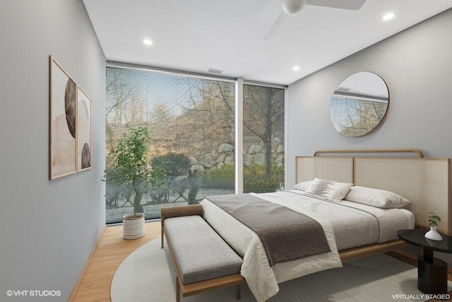 bedroom with recessed lighting, a ceiling fan, floor to ceiling windows, and wood finished floors
