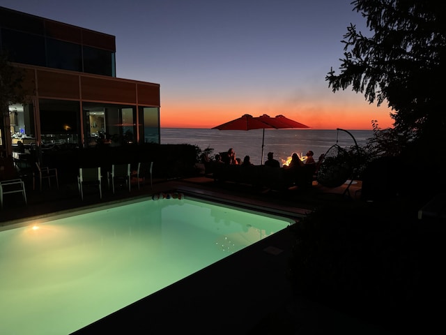 pool featuring a patio and a water view