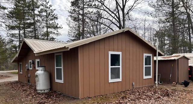 view of side of home with an outdoor structure and metal roof