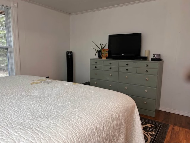 bedroom with crown molding, dark wood-style flooring, and baseboards