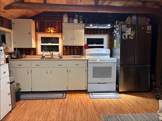 kitchen featuring freestanding refrigerator, a sink, light wood-style floors, beam ceiling, and electric range