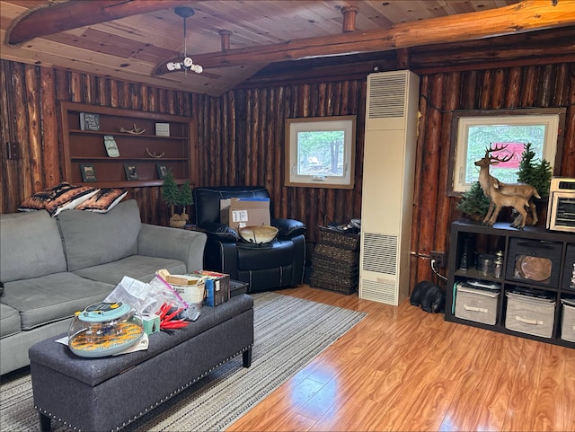 living area with light wood finished floors, a heating unit, wood walls, beamed ceiling, and wooden ceiling