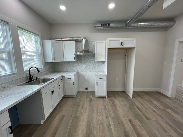 171 Davis St, Wyandotte, MI 48192 - kitchen with wall chimney range hood, a sink, light wood-type flooring, white cabinets, and recessed lighting