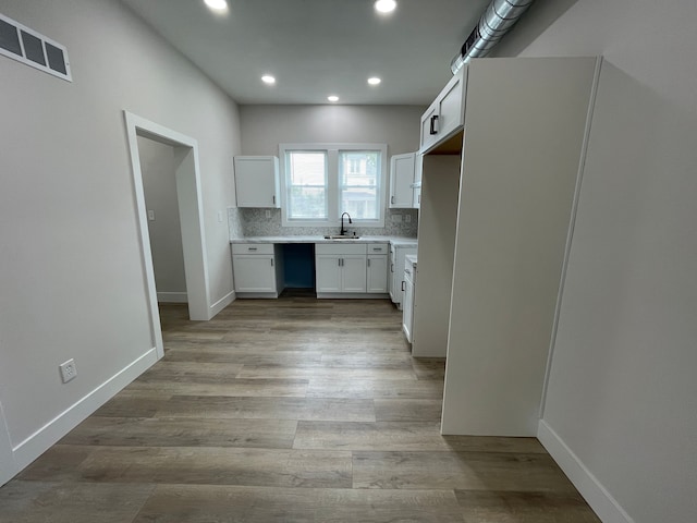 171 Davis St, Wyandotte, MI 48192 - kitchen with a sink, recessed lighting, light countertops, white cabinetry, and light wood-style flooring