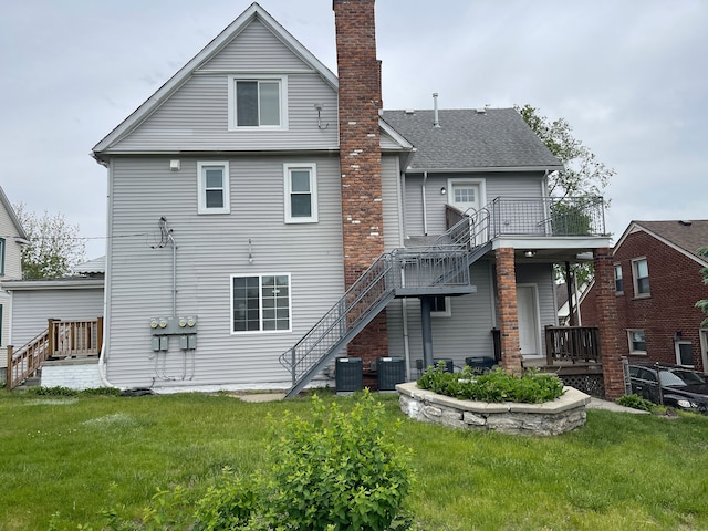 171 Davis St, Wyandotte, MI 48192 - rear view of house featuring stairway, a chimney, central air condition unit, and a yard