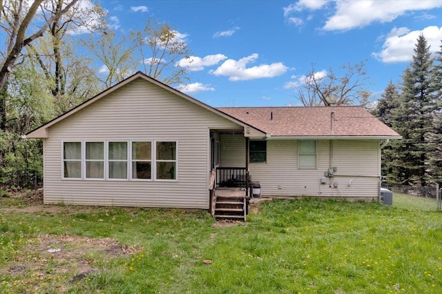 back of property featuring a shingled roof and cooling unit
