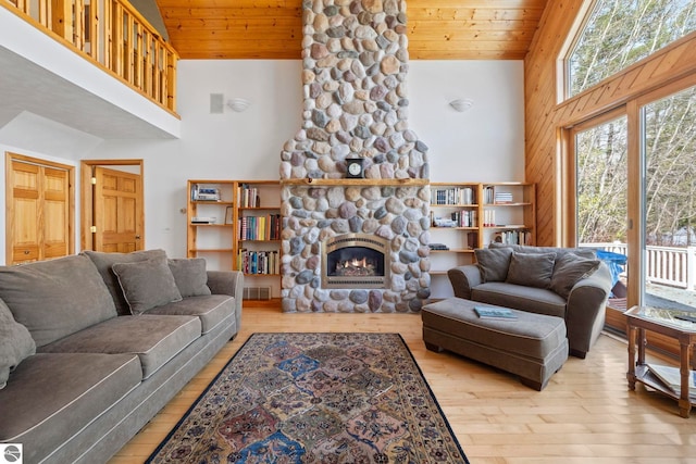 living area with high vaulted ceiling, wooden ceiling, hardwood / wood-style flooring, and a fireplace