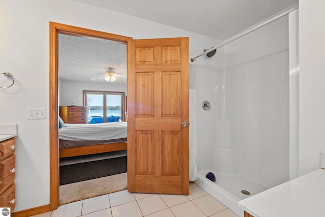 full bathroom featuring vanity, walk in shower, tile patterned floors, a ceiling fan, and ensuite bath