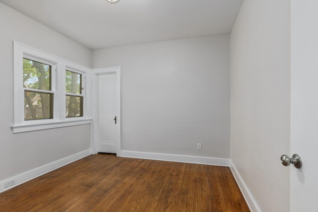 empty room with baseboards and dark wood finished floors