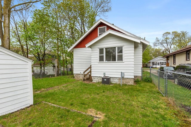 back of house with a lawn, a fenced backyard, central AC, and entry steps
