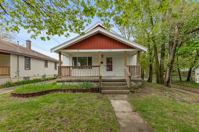 bungalow featuring a porch and a front lawn