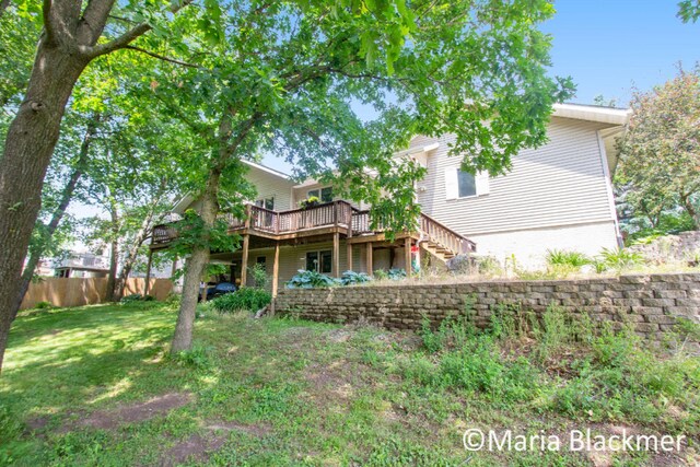 back of house featuring a yard, a deck, fence, and stairs
