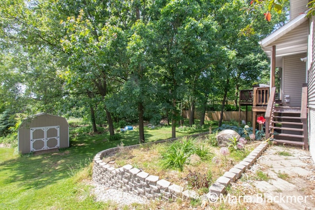 view of yard featuring stairway, a wooden deck, an outdoor structure, and a storage unit