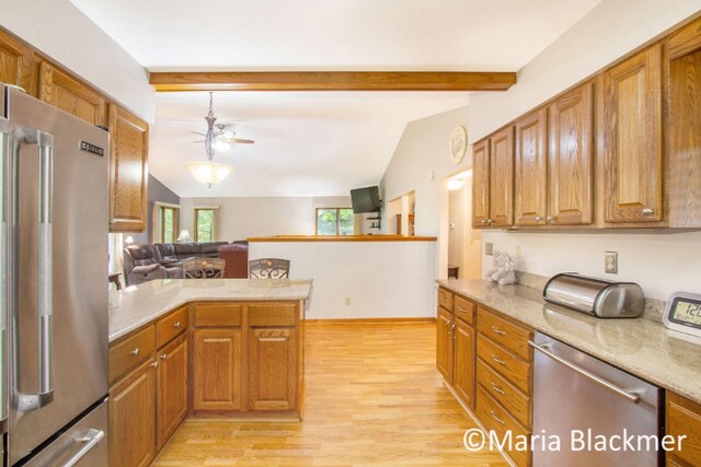 kitchen with brown cabinets, appliances with stainless steel finishes, lofted ceiling with beams, a ceiling fan, and light wood-type flooring
