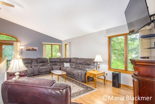 living area featuring ceiling fan, vaulted ceiling, plenty of natural light, and wood finished floors