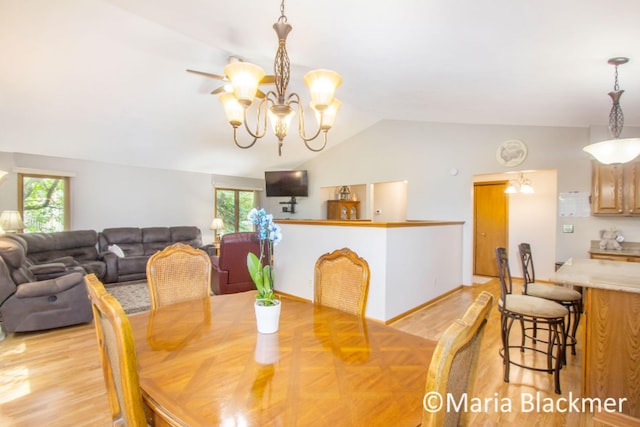 dining space featuring vaulted ceiling, light wood-type flooring, and a chandelier
