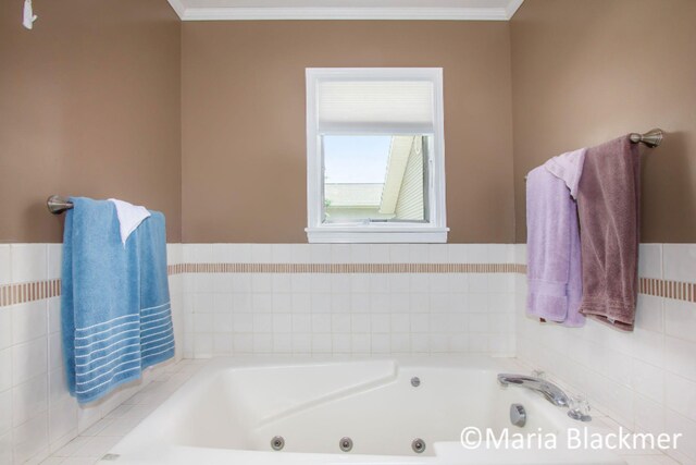 bathroom with ornamental molding and a jetted tub